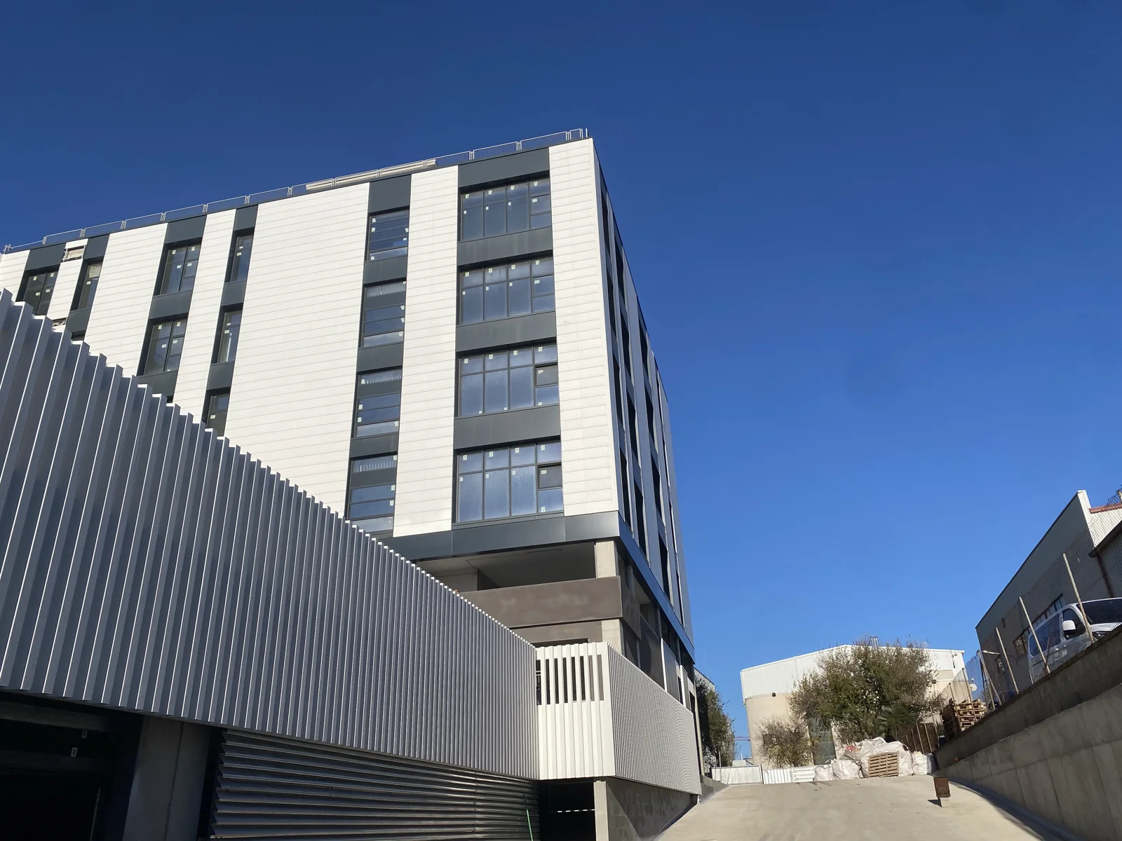 Fachada real del edificio Pablo Iglesias 21–27 bajo el cielo azul