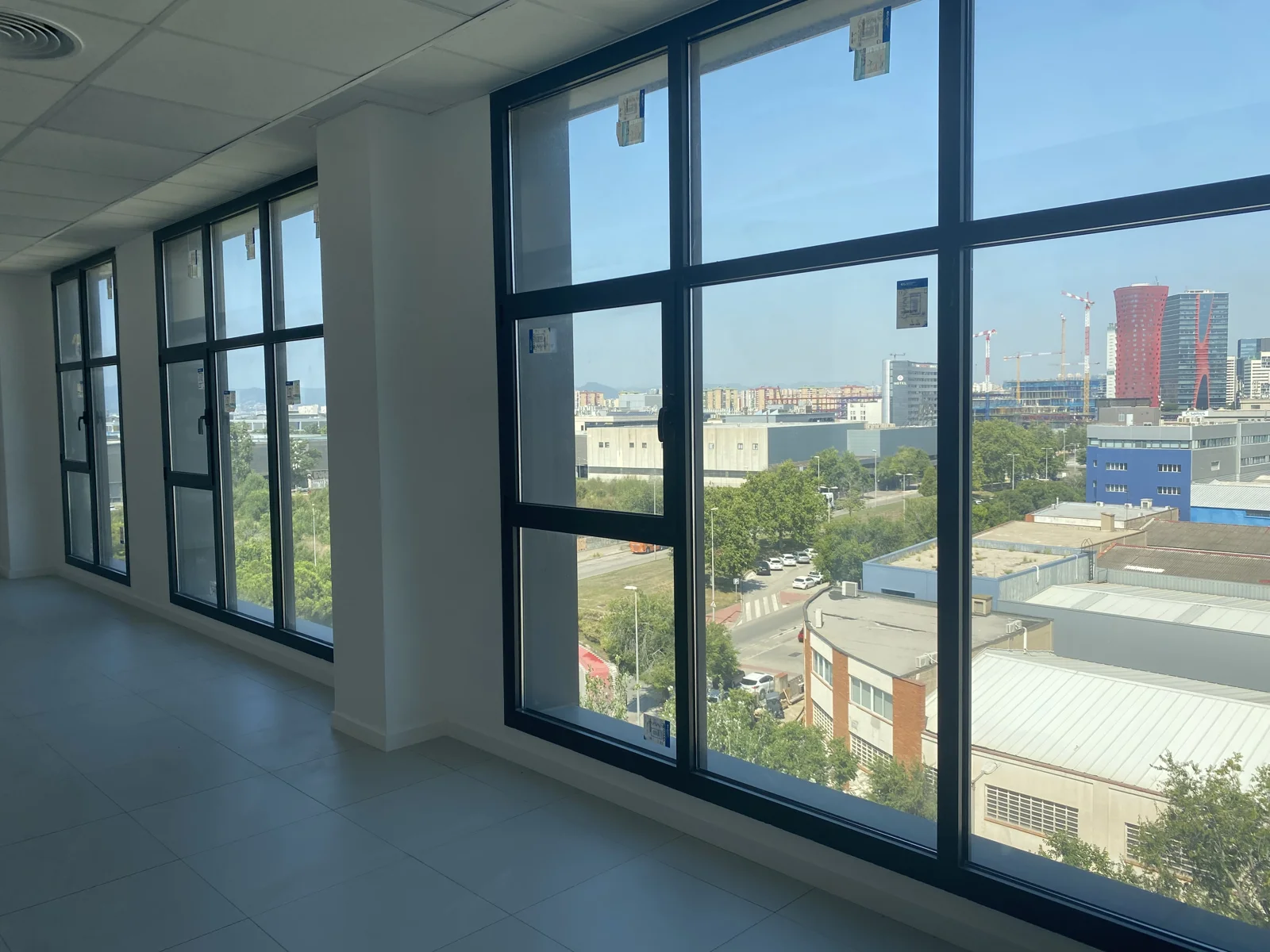 Ventanales de una oficina con vistas al entorno y a las torres Porta Fira